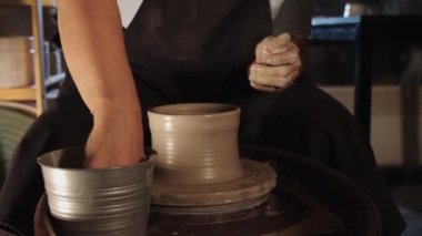 Akşamları atölyede kilden tencere yapan yaşlı bir kadının elleri. Orta çekim