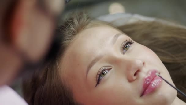 Καλλυντικός Εφαρμόζει Παυσίπονο Στα Παχουλά Χείλη Μιας Όμορφης Νεαρής Γυναίκας — Αρχείο Βίντεο