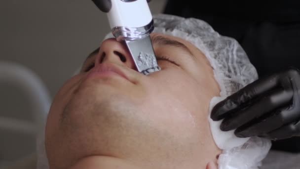 Kosmetolog Czyści Twarz Człowieka Pomocą Płuczki Ultradźwiękowej Środek Strzału — Wideo stockowe