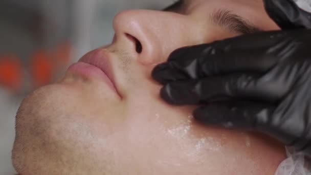 Cosmetoloog Reinigt Huid Van Een Gezicht Van Mens Met Behulp — Stockvideo