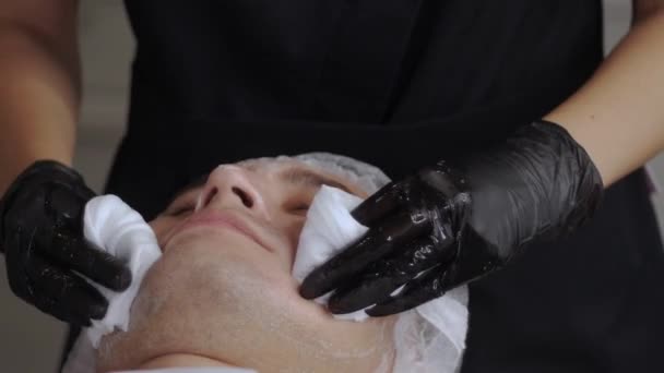 Kosmetolog Avlägsnar Produkten Från Ansiktet Den Manliga Klienten Med Hjälp — Stockvideo
