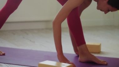 İnce ve uzun boylu kadın oturma odasında yoga egzersizleri yapıyor. Orta çekim