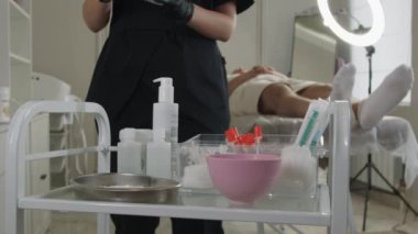08-30-22 RUSSIA, KAZAN: güzellik tedavileri - kozmetolog müşteri için bir maske karıştırıyor - bir kaseye kuru toz döküyor. Orta çekim