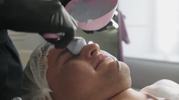 Zabiegi Kosmetologiczne Kosmetolog Nakłada Płynną Maskę Twarz Męskiego Klienta Środek — Wideo stockowe
