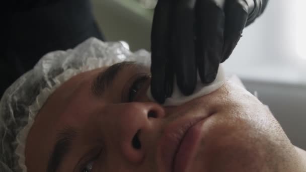 Zabiegi Kosmetologiczne Kosmetolog Oczyszcza Skórę Twarzy Męskiego Klienta Środek Strzału — Wideo stockowe