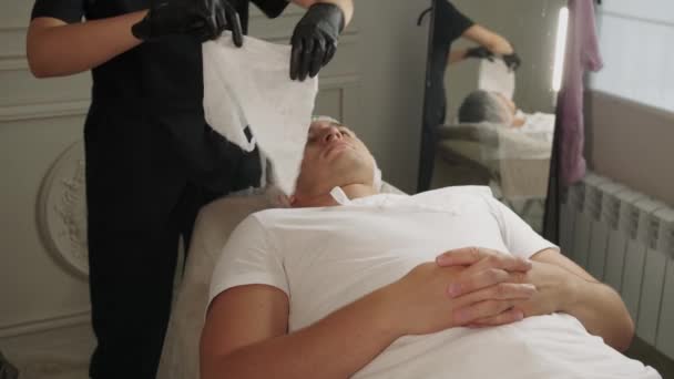 美容疗法 美容师在手术前用餐巾纸封闭男性患者的胸部 — 图库视频影像
