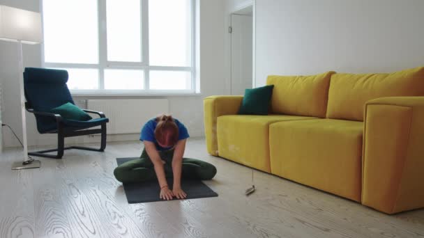 成年女子在客厅里做瑜伽 地板上放着熏香 — 图库视频影像