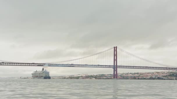 ポルトガル リスボン 2022 リスボンの橋の下に大きな金属製のクルーズ船があります ミッドショット — ストック動画