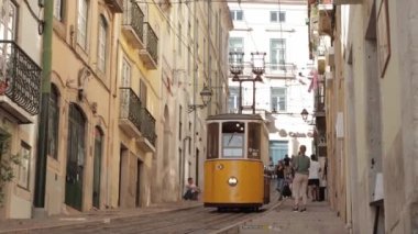 Lizbon, Portekiz - 10-11-2022: İnsanlardan geçen tarihi sarı tramvay. Orta çekim