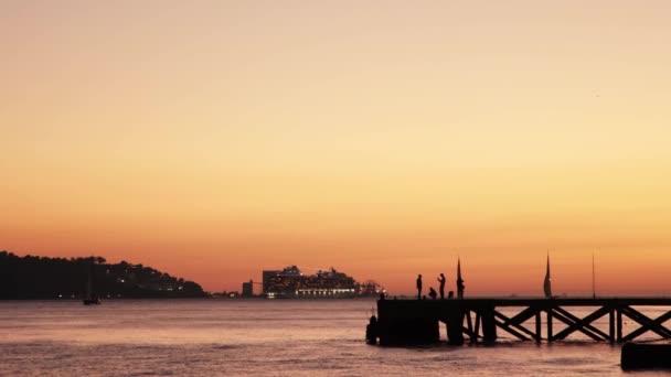 橙色落日景观 人们站在码头上和一艘在河上航行的旅游船上 — 图库视频影像