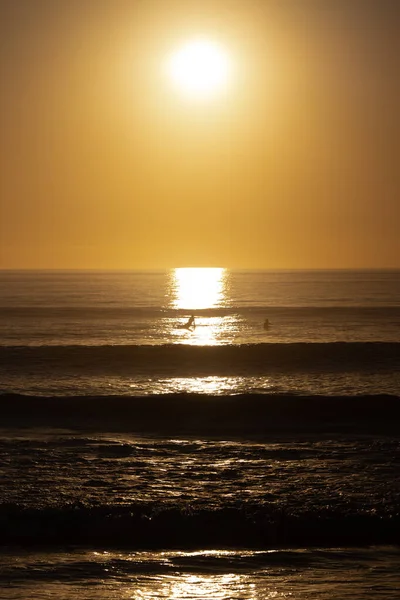 Pôr Sol Laranja Acima Oceano Poucas Pessoas Nadando Tiro Vertical — Fotografia de Stock