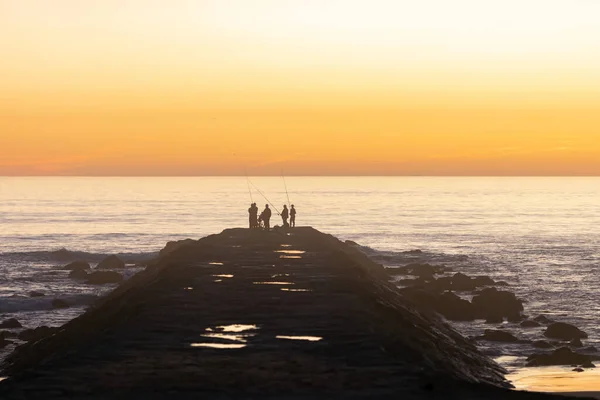 Яскраво Помаранчевий Захід Сонця Над Океаном Чорні Силуети Людей Які — стокове фото