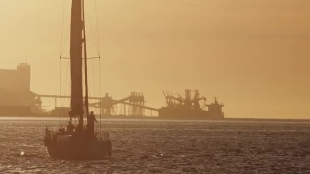 Nsanlar Günbatımında Yelkenli Teknede Eğleniyorlar Arka Planda Endüstriyel Vinçler Var — Stok video
