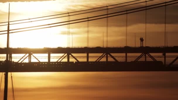 橙色夕阳西下有一座两层高的桥 下层有一辆电车经过 — 图库视频影像