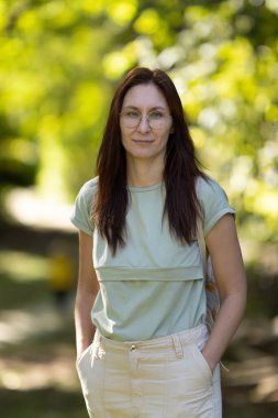 Yeşil parkta duran bir kadın. Orta çekim