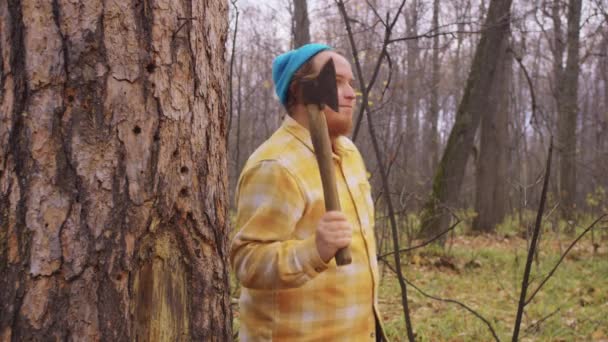 肩に斧を持った木の後ろから髭を生やしたルンベルジャックが現れる 肖像画 — ストック動画