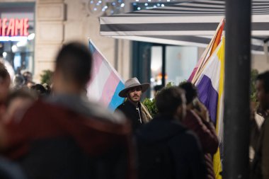 PORTUGAL, LISBON 11-25-2022: Kadınlara Karşı Şiddetin Sonu Yürüyüşü - travesti bayrağı taşıyan bir adam. Orta çekim