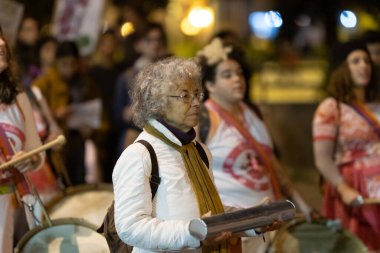 PORTUGAL, LISBON 11-25-2022: Kadınlara Karşı Şiddetin Sonu Yürüyüşü - mitingde yürüyen yaşlı bir kadın. Orta çekim