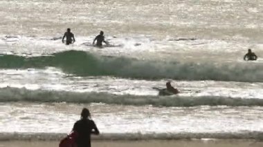 Surfing in the ocean at early evening. Mid shot