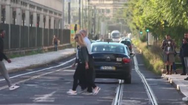 PORTUGAL, LISBON 09-11-2022: people cross the road on tram tracks. Mid shot