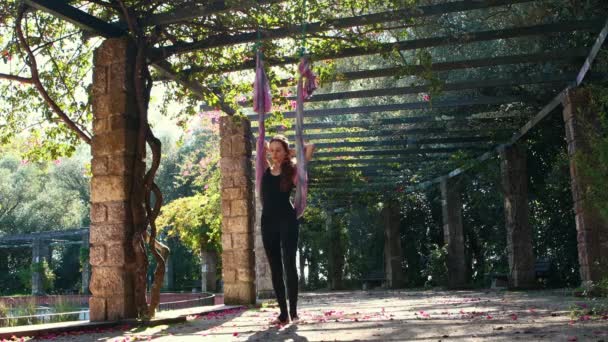 ヨガハンモックを使って屋外で運動する女性 ミッドショット — ストック動画