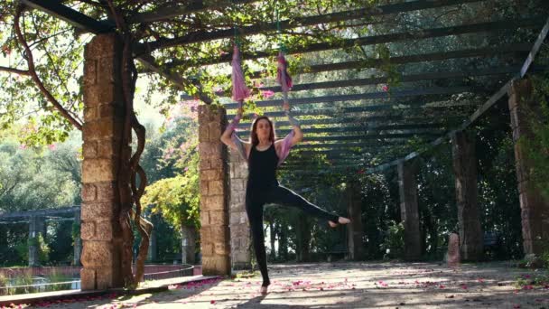 一个女人脱下鞋子爬到花园里的一个瑜伽吊床上 — 图库视频影像
