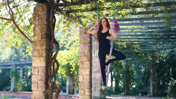 一名妇女用瑜伽吊床做空中瑜伽练习 她单腿站在吊床上 把手掌放在一起 — 图库视频影像