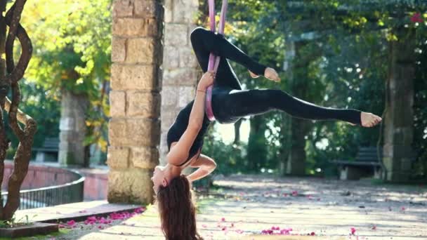 一个女人正在做空中瑜伽 头朝下吊在吊床上 — 图库视频影像
