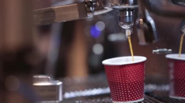 Espresso is poured into a cardboard cup. Mid shot