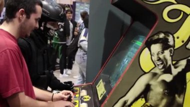 11-17-2022 LISBON, PORTUGAL - two men playing arcade games at the gaming expo. Mid shot