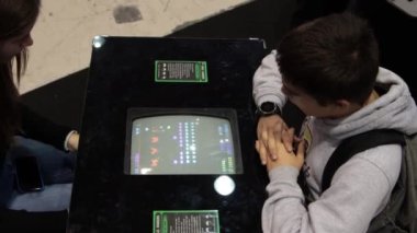 11-17-2022 LISBON, PORTUGAL - a little boy looks at a screen with a retro game at a gaming exhibition. Mid shot