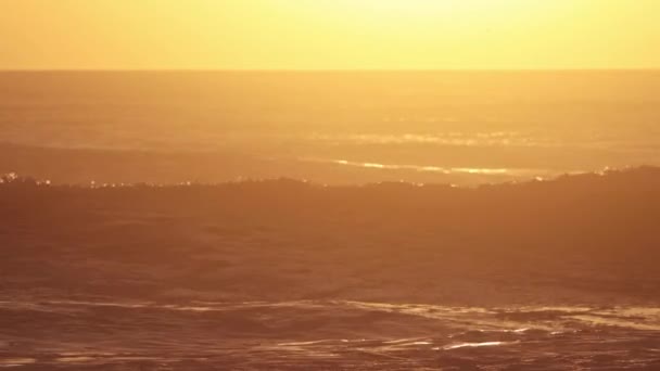オレンジ色の夕日に海の波が飛び込む ミッドショット — ストック動画