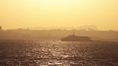 Yacht sails the river at an orange sunset. Mid shot