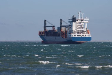 A big cargo ship sails the sea. Mid shot