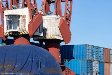 Lifting cranes and multi-colored cargo containers in the seaport. Mid shot