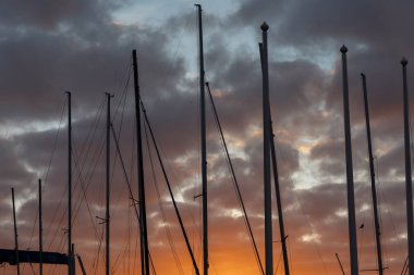 Boat spires against the backdrop of the sunset sky. Mid shot