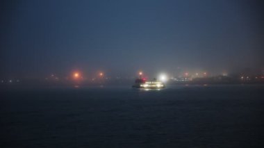 Glowing boat floating in the sea in fog. Mid shot