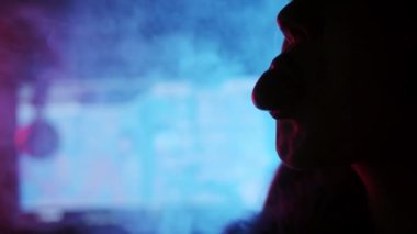 Silhouette of a gamer girls face - chews gum and inflates a bubble from chewing gum. Close up