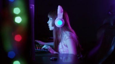 Cute gamer girl playing a game then finishes and flexing her neck. Mid shot