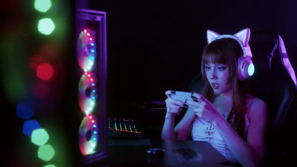 Roztomilé Hráčka Dívka Sedí Osvětlené Neonovými Světly Hraje Svém Telefonu — Stock video