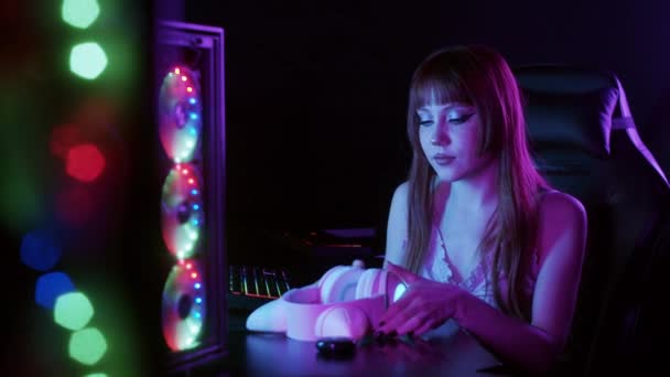 Neon Nin Yanında Oturan Sevimli Oyuncu Kız Kulaklıklarını Kedi Kulaklığıyla — Stok video