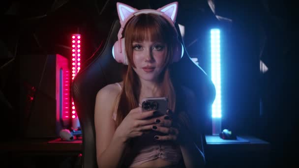 Pretty Gamer Girl Wearing Bright Makeup Holding Her Phone Look — Vídeo de stock