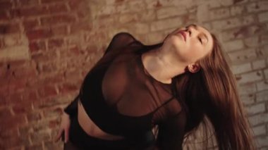 Sexy woman with long hair dancing in the studio. Mid shot