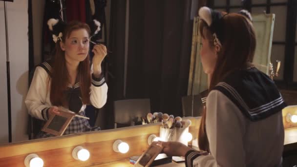 Uma Menina Bonita Fazendo Maquiagem Nos Bastidores Olhando Espelho Grande — Vídeo de Stock