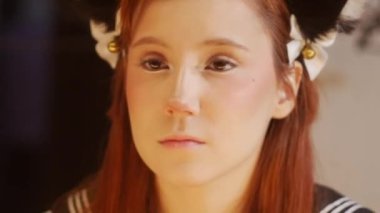 A cute ginger girl doing eye makeup. Mid shot