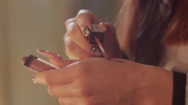 A woman swatching nude lipstick on her hand. Close up