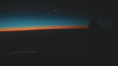 Bright red horizon line in the sky at the early sunrise. Passenger POV from the plane