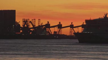 13-01-2023 Lisbon, Portugal: TT-Line Green ship sailing on the river at a bright sunset near industrial constructions. Mid shot
