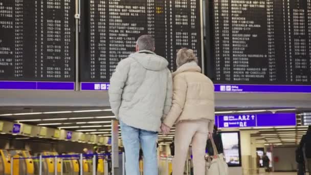 Cute Elderly Couple Looks Scoreboard Planes Departures Mid Shot — Stock video