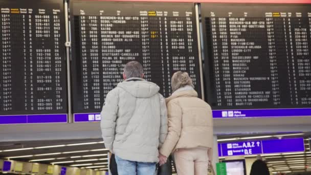 Elderly Couple Looks Scoreboard Planes Departures Mid Shot — Stock video